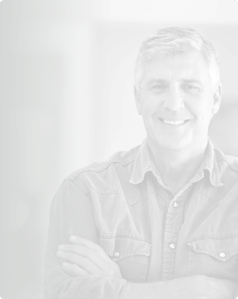 Older man in collared shirt smiling with his arms crossed
