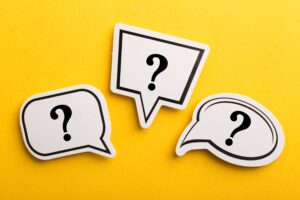 3 comic book question mark cutouts on a yellow background